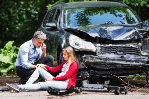 Man helping woman after car wreck injury